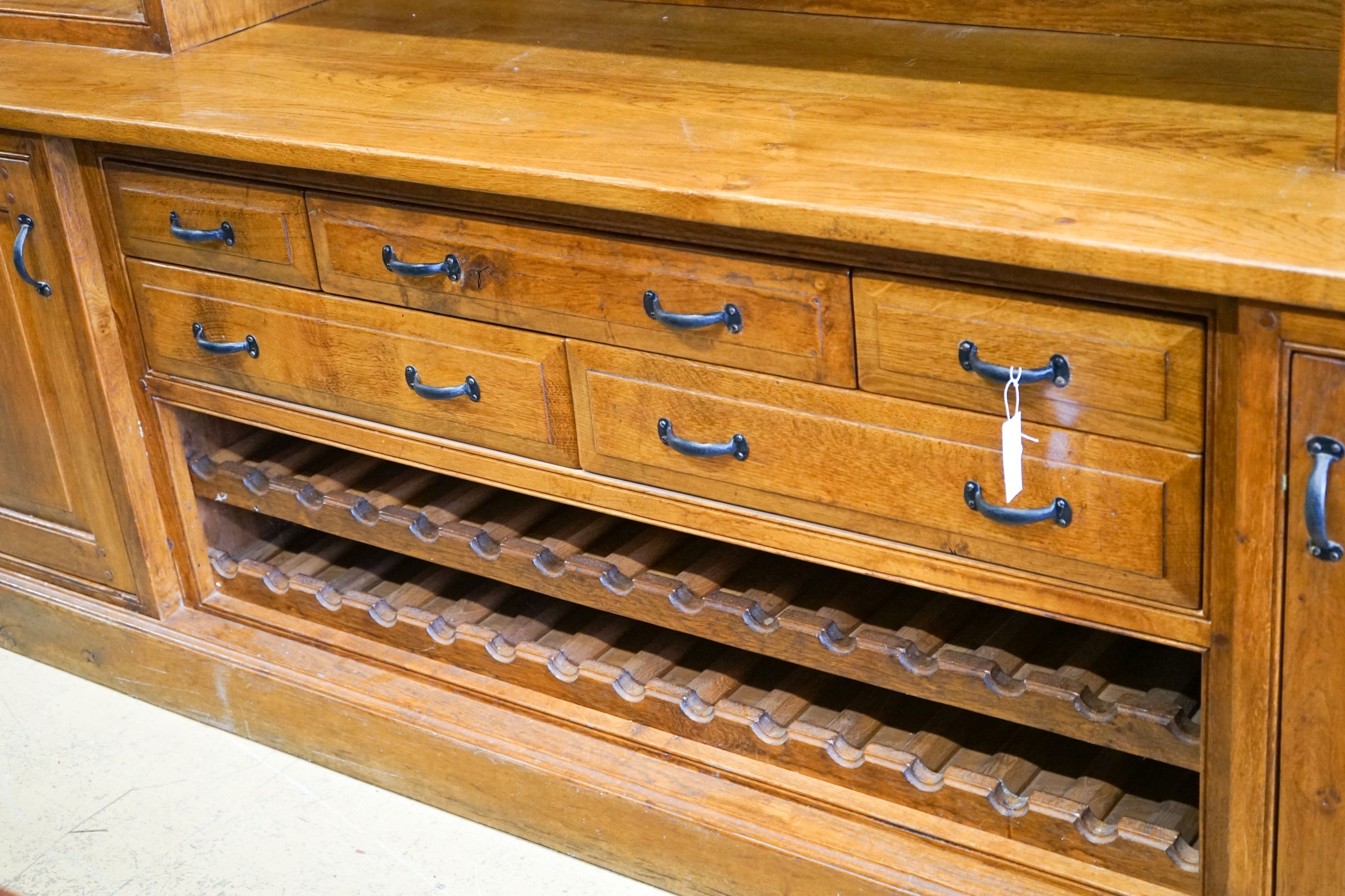 A large reproduction oak dresser with wine bottle storage, length 244cm, depth 60cm, height 201cm